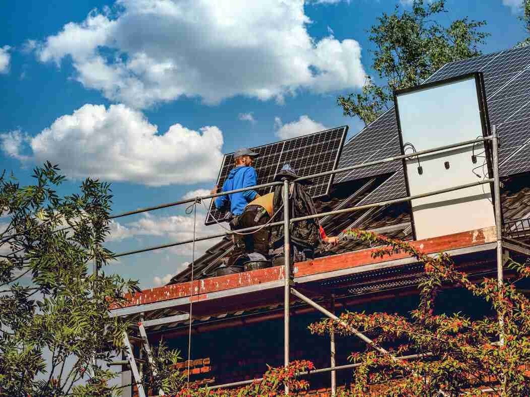 Zwei Arbeiter, die gerade eine Photovoltaikanlage anbringen.