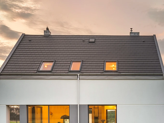 Ein Einfamilienhaus ist zu sehen. Im Inneren brennt Licht.