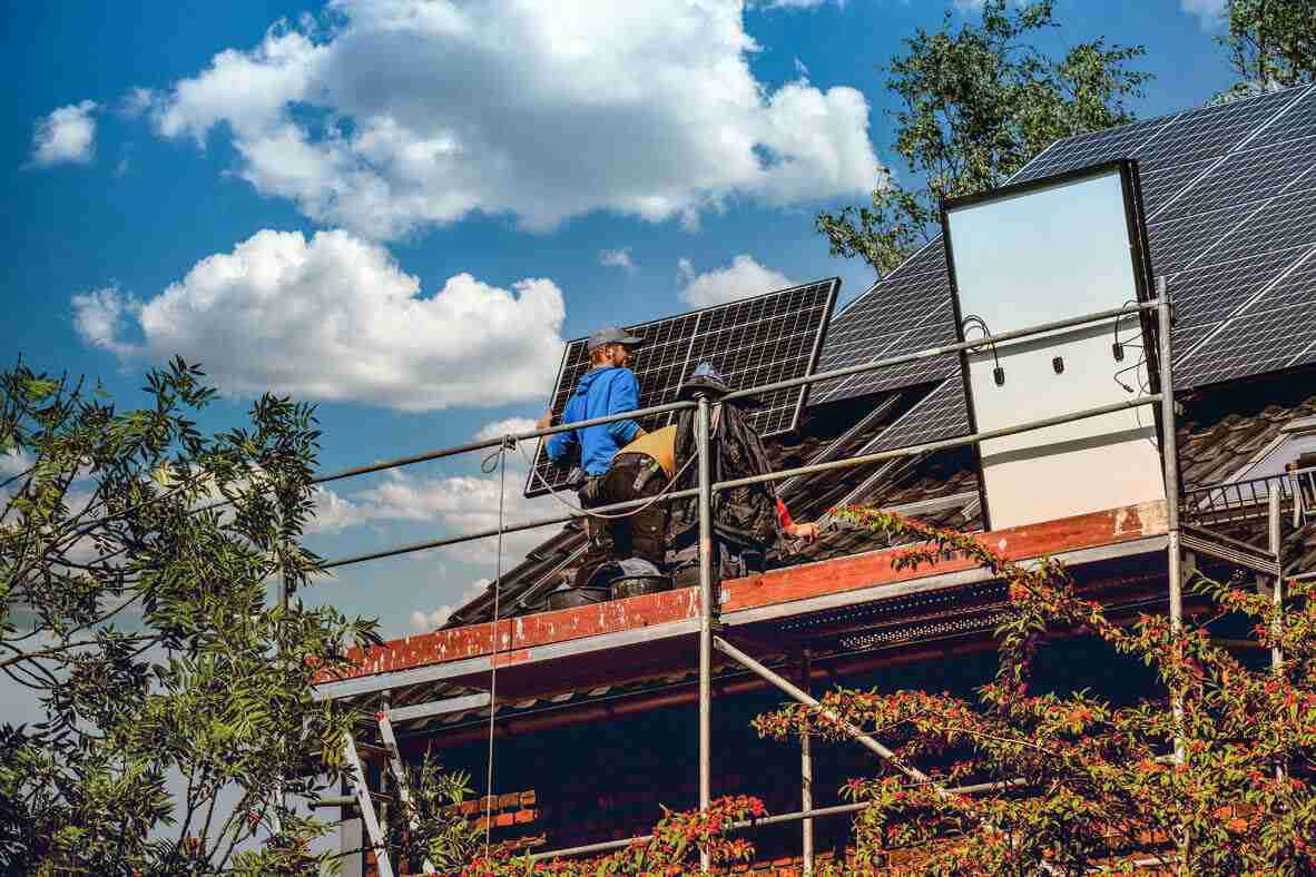 Zwei Arbeiter, die gerade eine Photovoltaikanlage anbringen.