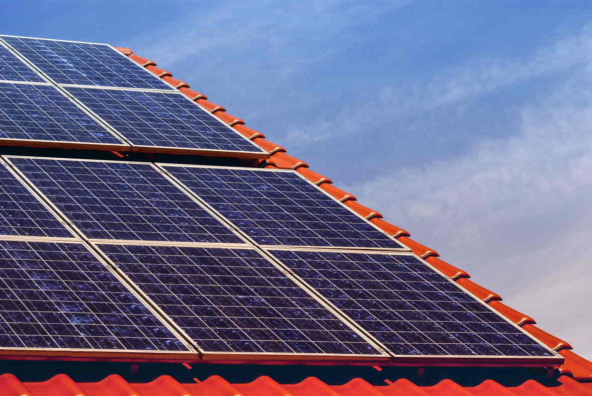 Mehrere Solarpanels einer Photovoltaikanlage, die auf einem Dach angebracht sind.