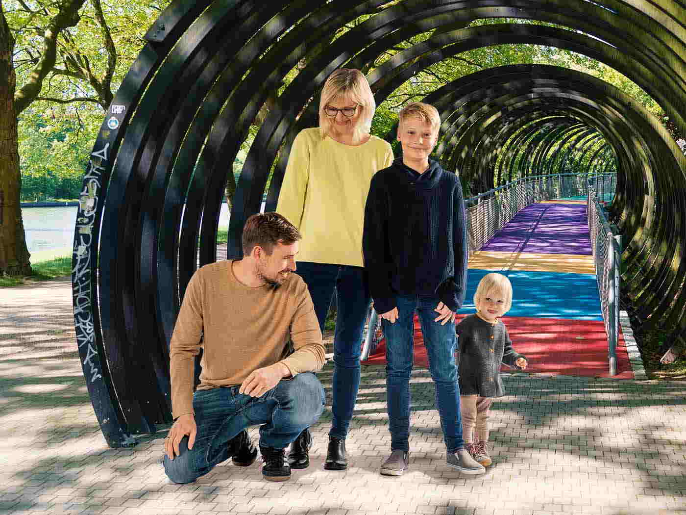 Die Aufnahme einer Familie mit zwei Kindern. Sie stehen vor der Brücke, die über den Rhein-Herne Kanal führt.