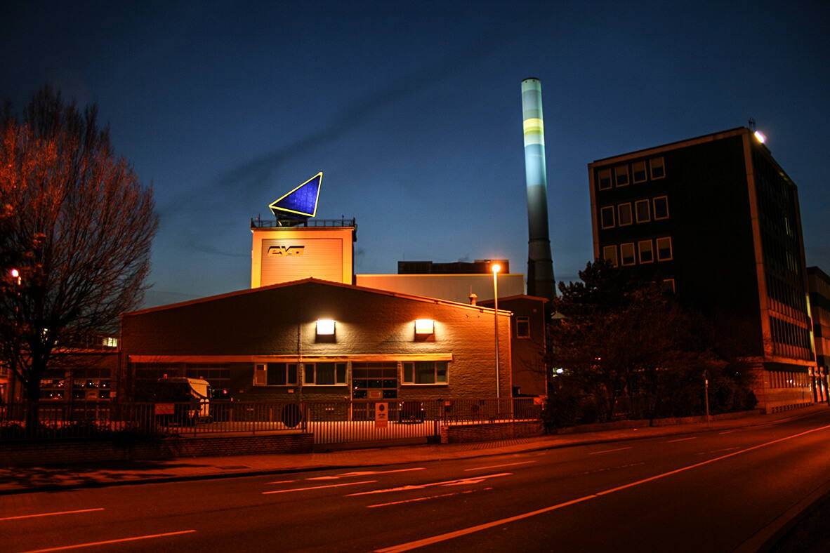 Eine Aufnahme des beleuchteten evo Gebäudes, bei Nacht.